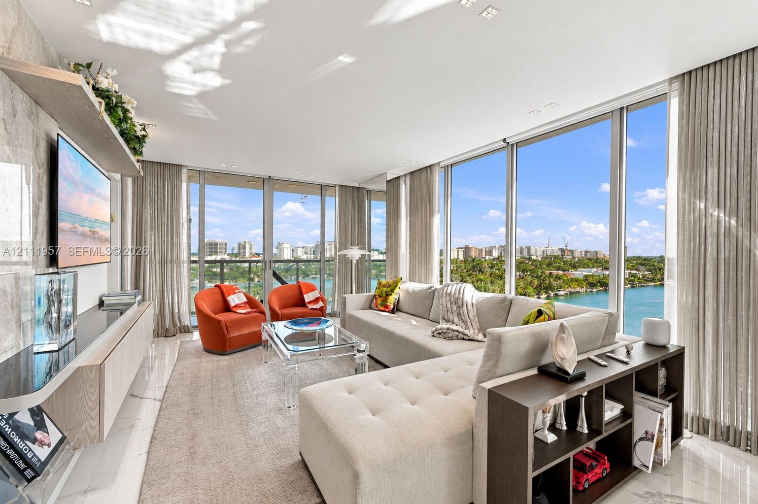 Floor-to-ceiling glass windows, stone-finish flooring, and a wall-mounted light-wood cabinetry unit Floor-to-ceiling glass windows, stone-finish flooring, and a wall-mounted light-wood cabinetry unit
