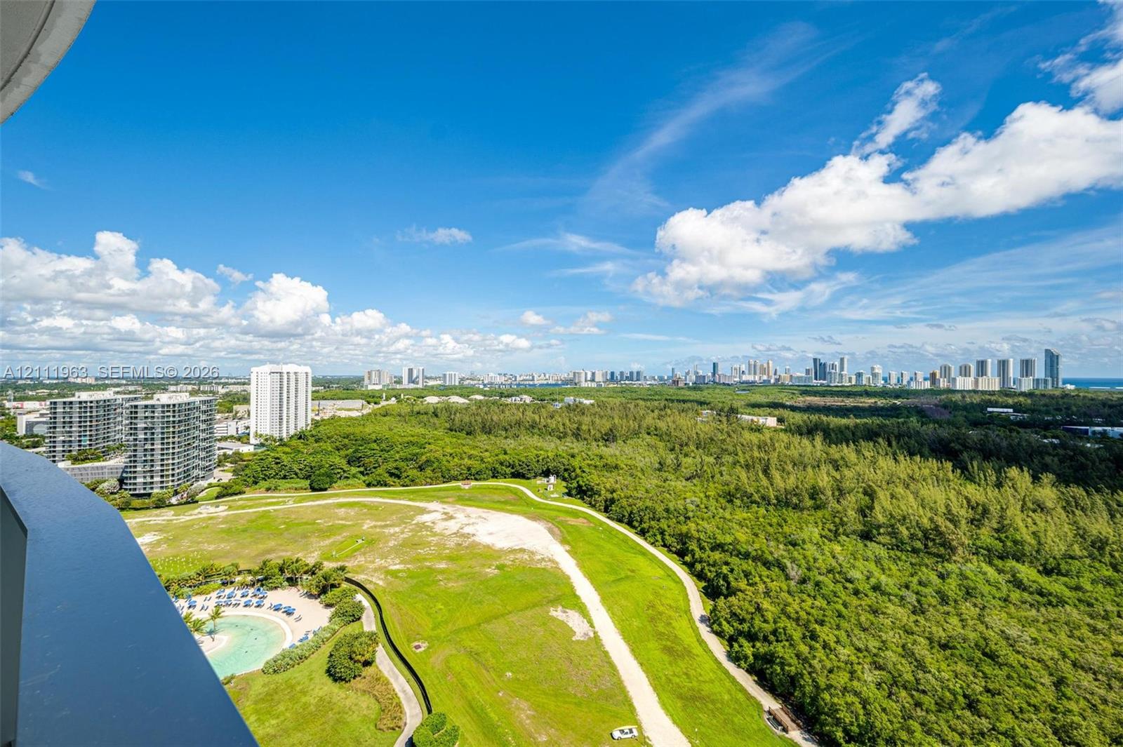 Curved balcony featuring large-format porcelain tile flooring and a glass panel railing