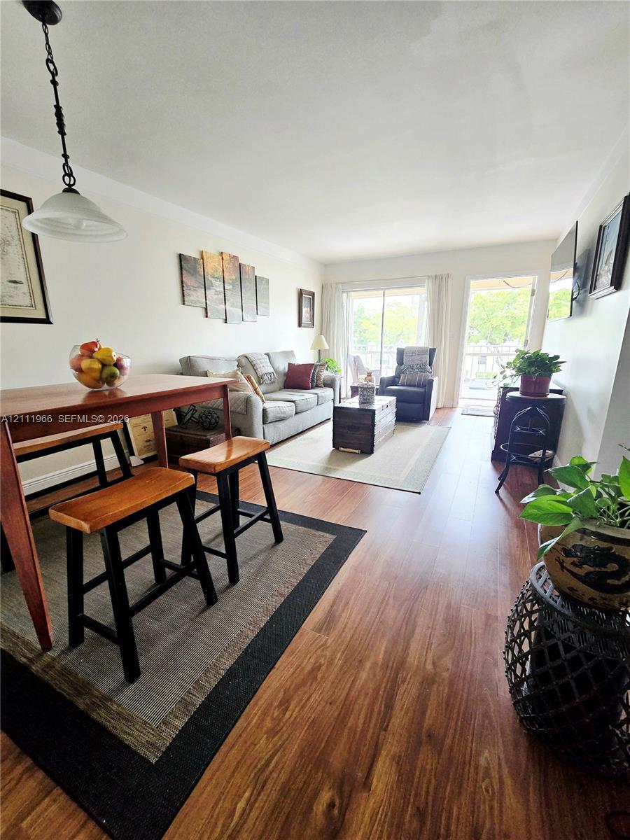 Wood-finish flooring throughout, sliding glass patio door, and pendant lighting fixture