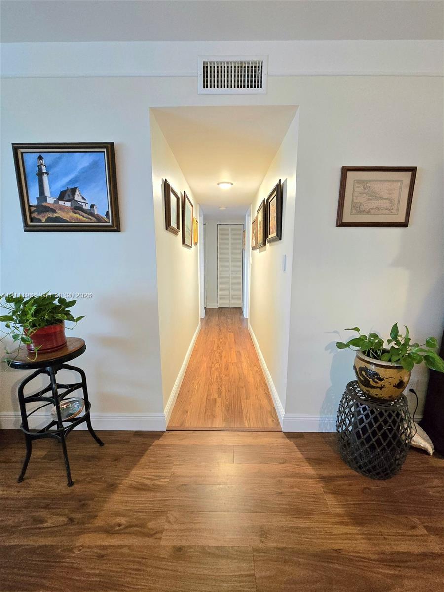 Interior hallway featuring wood-finish flooring and bi-fold closet doors
