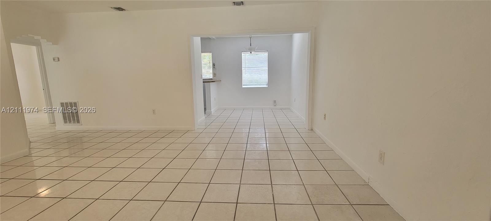 Neutral-toned ceramic tile flooring, crisp white interior paint, and recessed ceiling lighting