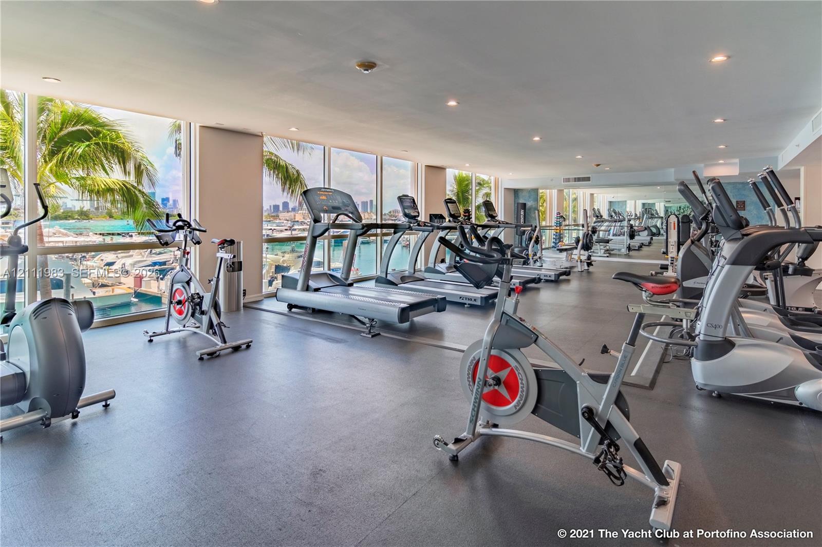 Fitness center featuring floor-to-ceiling windows, rubberized flooring, and recessed ceiling lighting