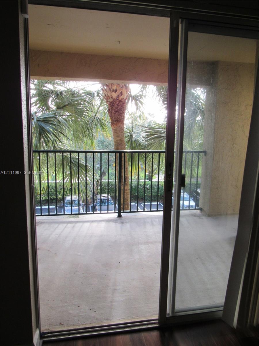 Covered balcony featuring concrete flooring and black metal railing