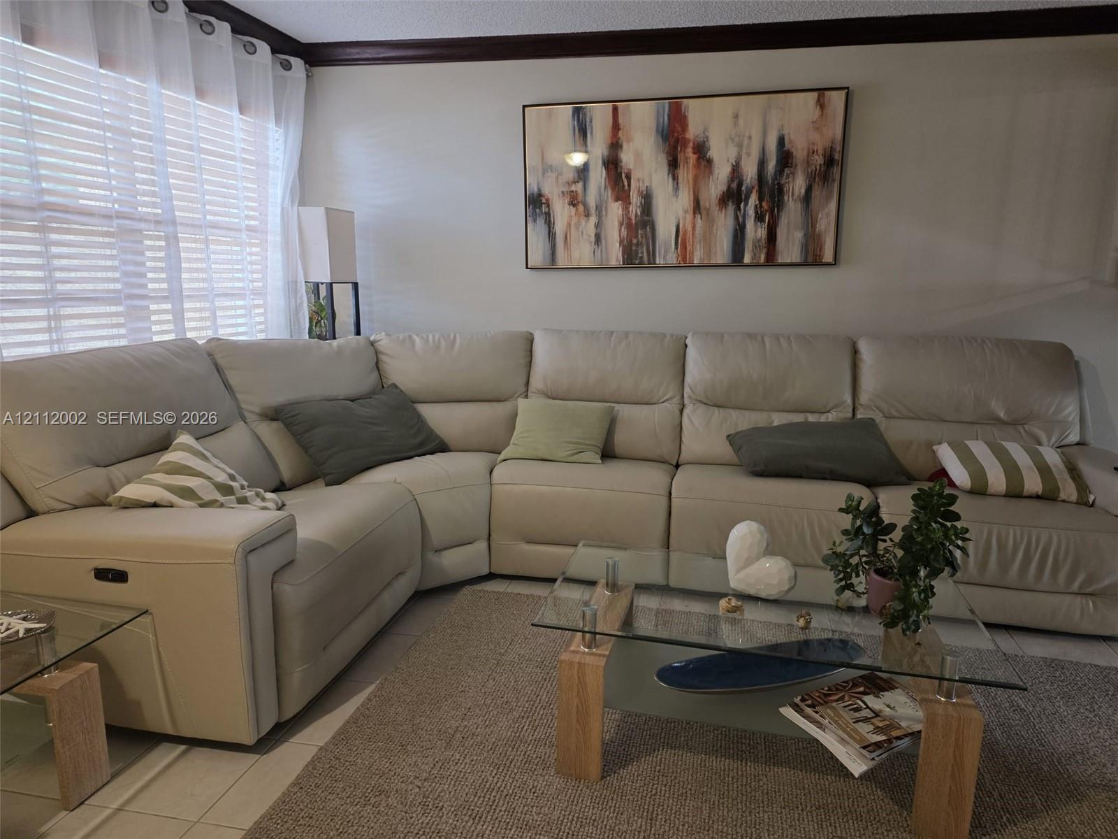 Interior room featuring neutral wall paint, multi-paned window, and dark crown molding
