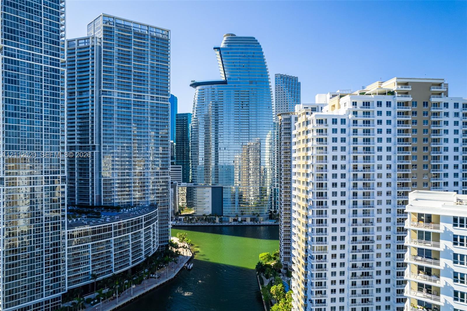 High-rise urban setting featuring reflective glass facades, balconies, waterfront access, and dense metropolitan architecture