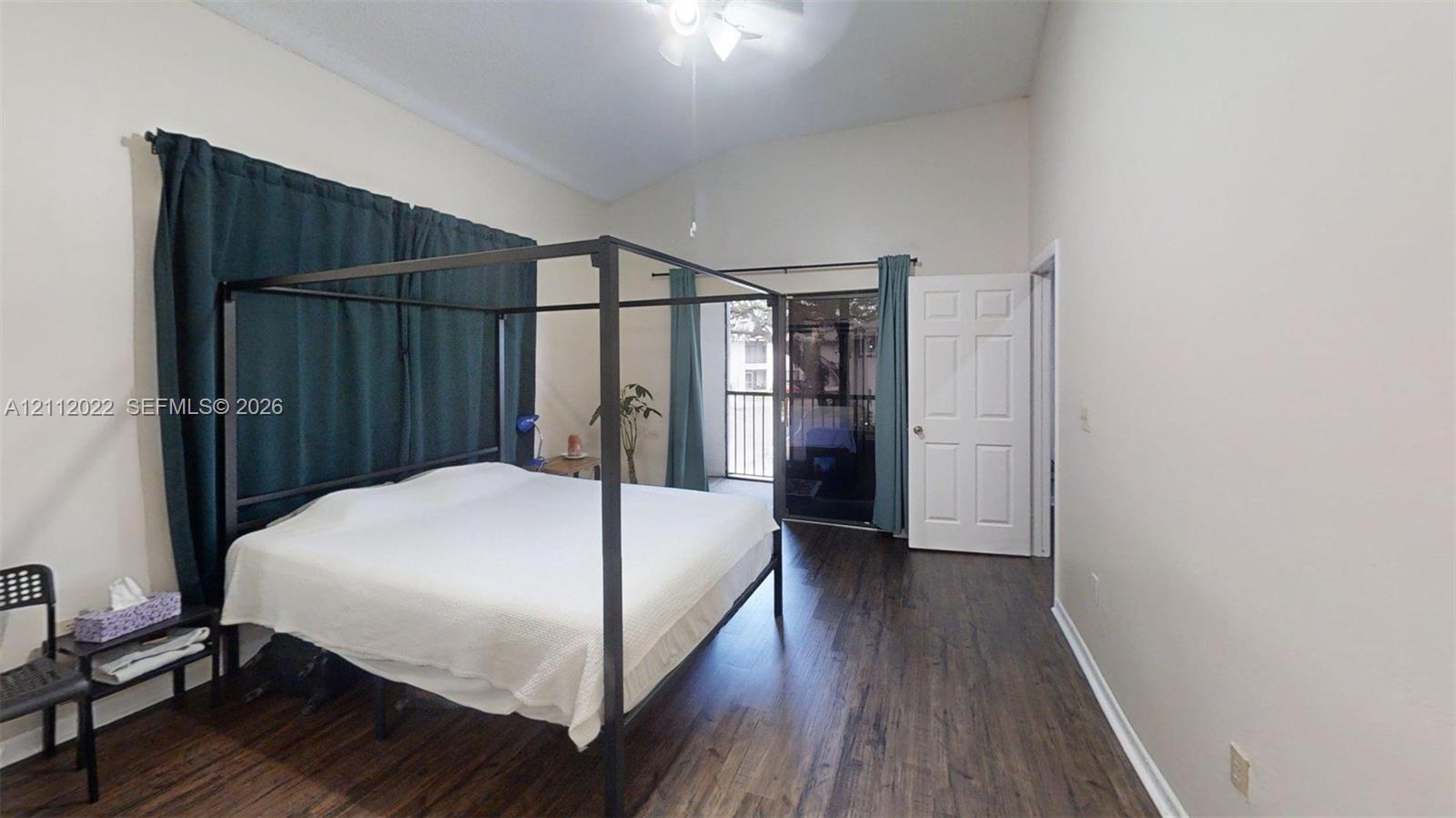 Vaulted ceilings, wood-finish flooring, and sliding glass doors providing outdoor access