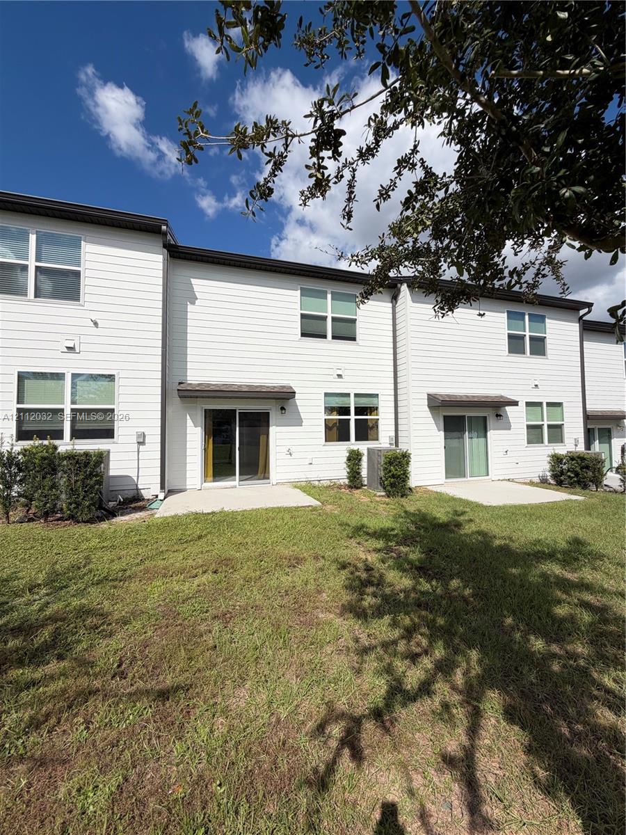 Multi-family exterior featuring horizontal siding, concrete rear patios, sliding glass doors, and dual-pane windows Multi-family exterior featuring horizontal siding, concrete rear patios, sliding glass doors, and dual-pane windows