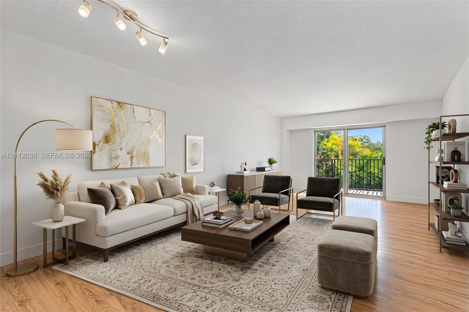 Living area featuring wood-finish flooring, adjustable track lighting, and sliding glass doors with access to a railed balcony