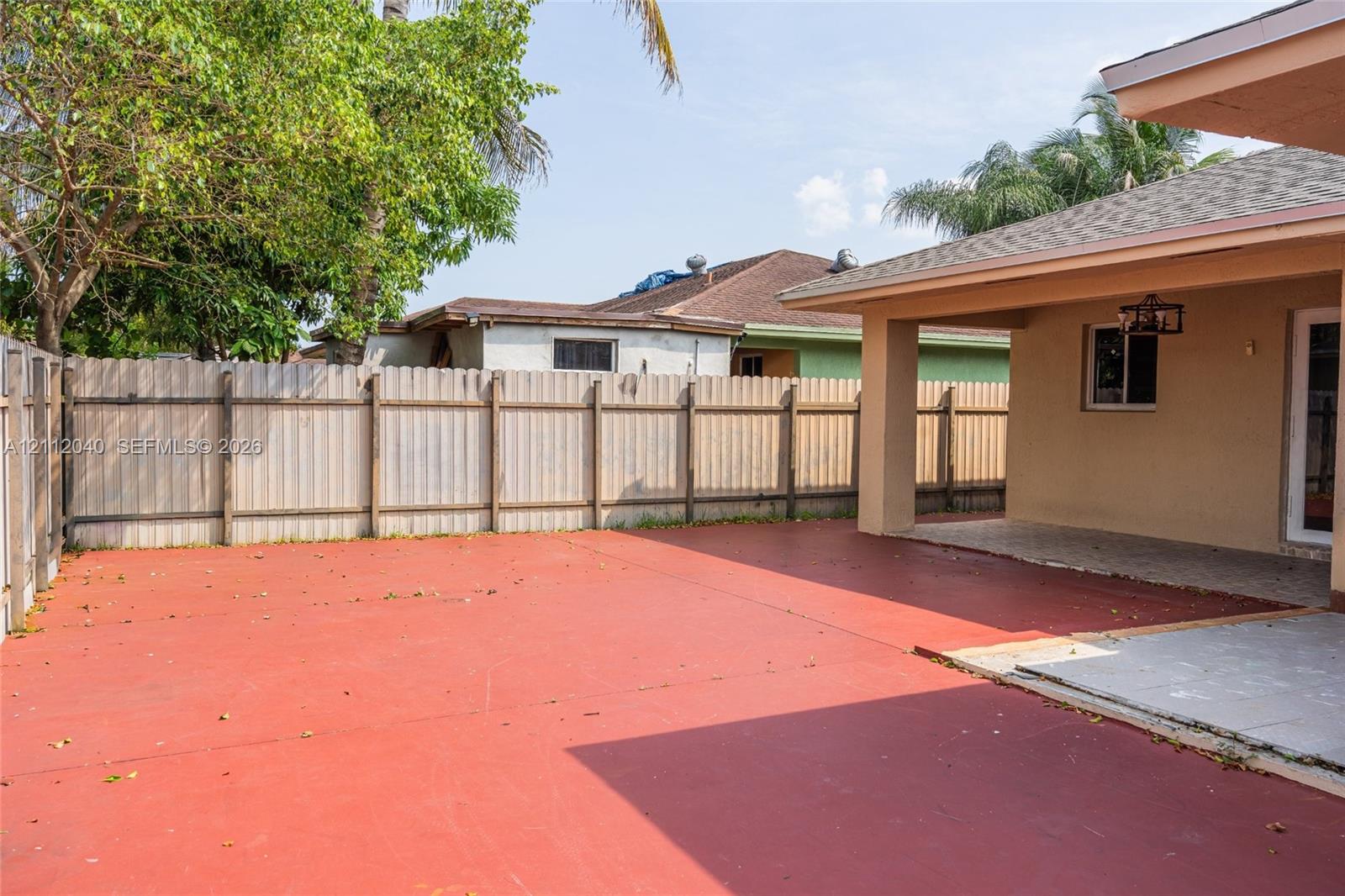 Backyard featuring a paved patio, a covered porch, and a full-height perimeter fence