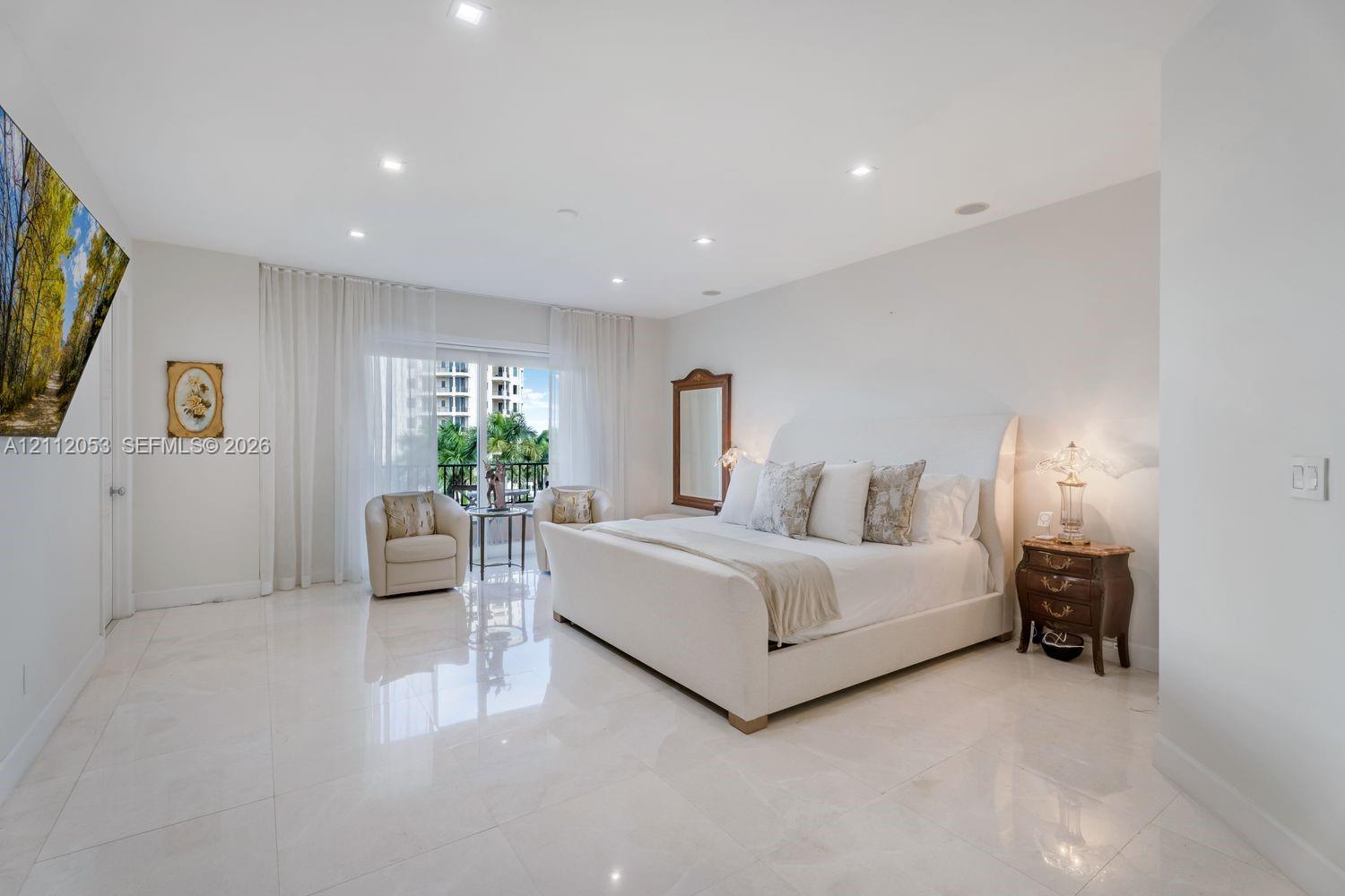Spacious interior featuring large-format polished tile flooring, recessed lighting, and sliding glass doors with floor-to-ceiling drapery