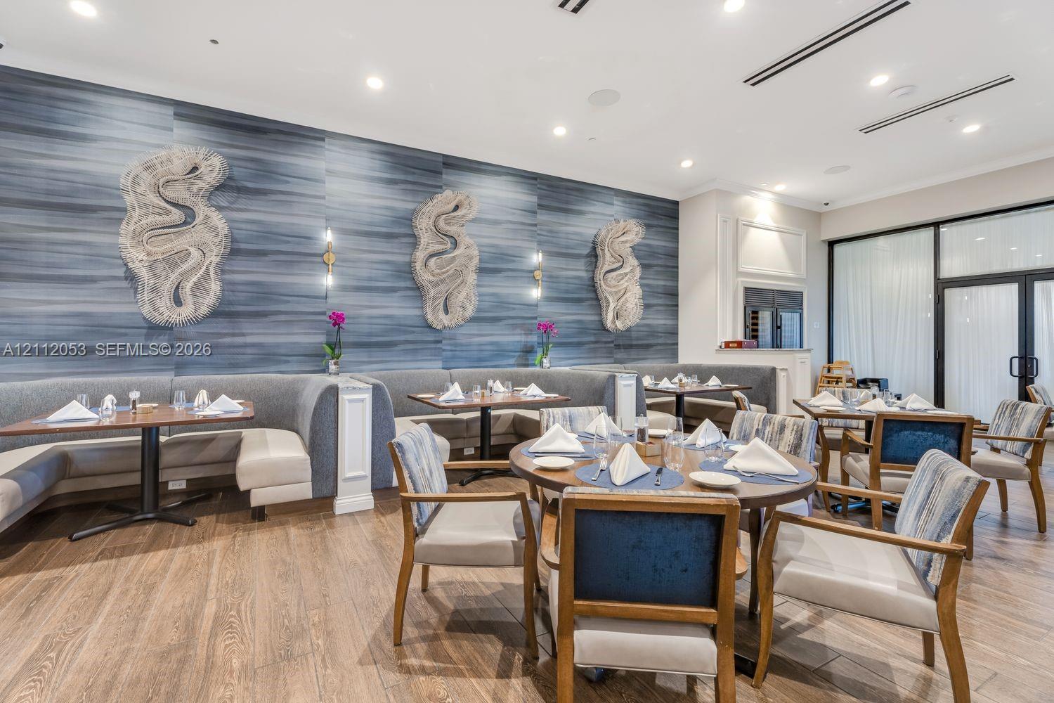 Textured blue accent wall featuring decorative wall sculptures, recessed lighting, and wood-finish flooring