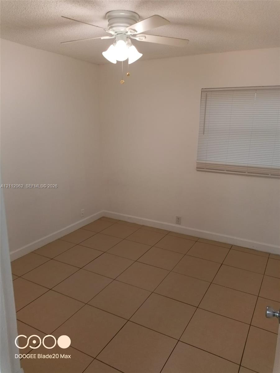 Room featuring ceramic tile flooring, a multi-light ceiling fan, and window blinds