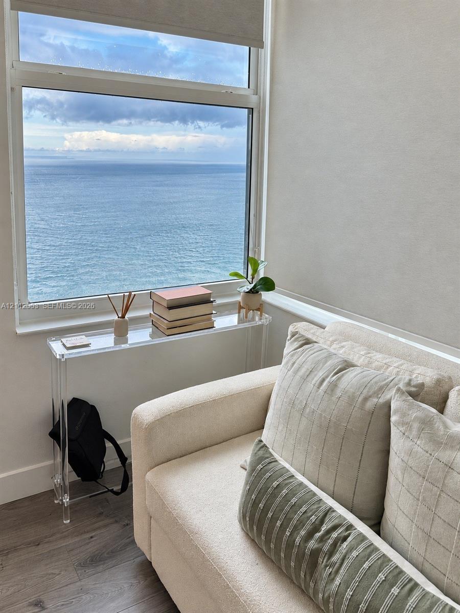 Large-format window featuring ocean scenery, wood-finish flooring, and roller shade hardware Large-format window featuring ocean scenery, wood-finish flooring, and roller shade hardware