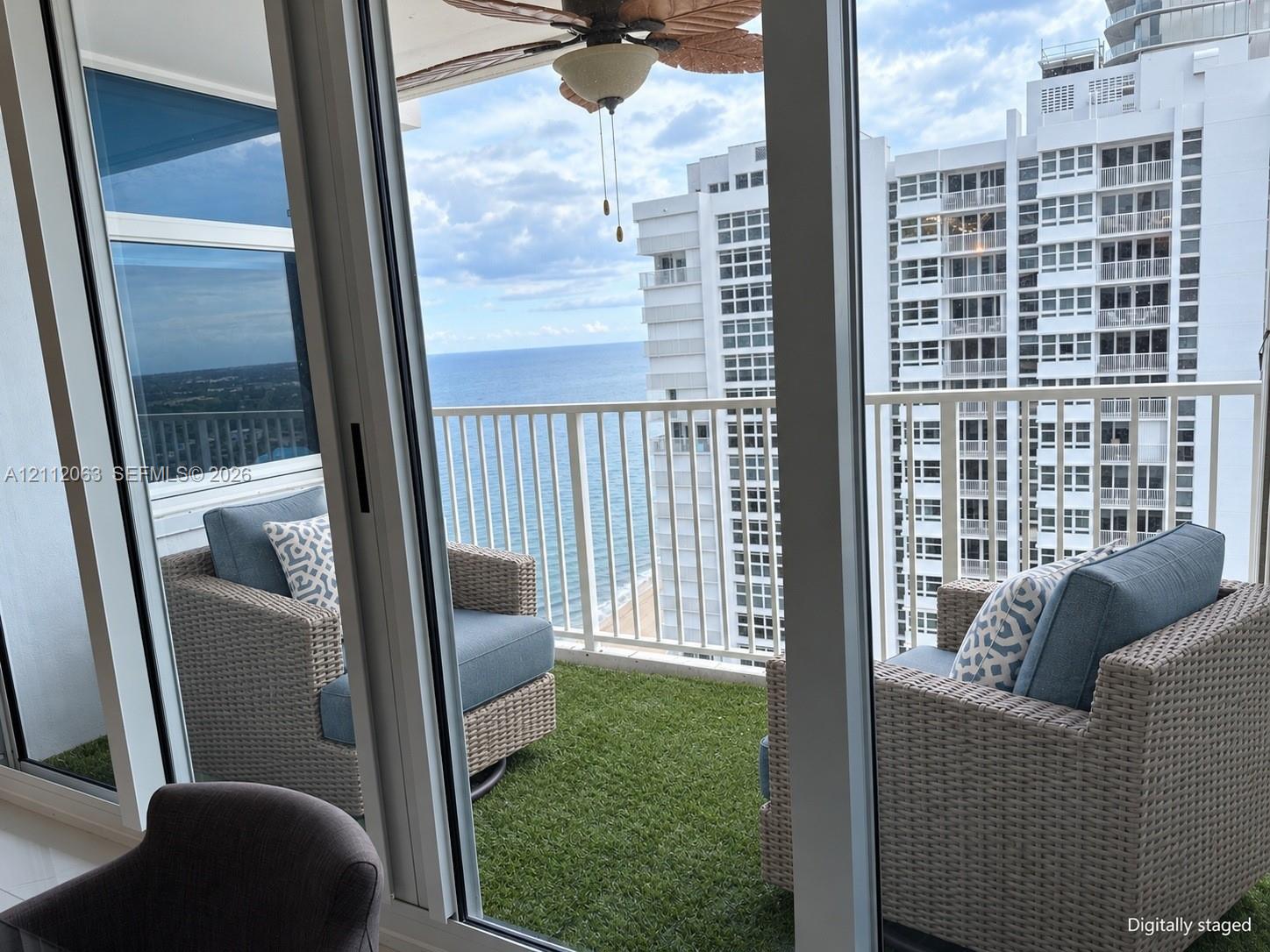 Private balcony featuring artificial turf flooring, white metal railing, and ocean horizon backdrop Private balcony featuring artificial turf flooring, white metal railing, and ocean horizon backdrop