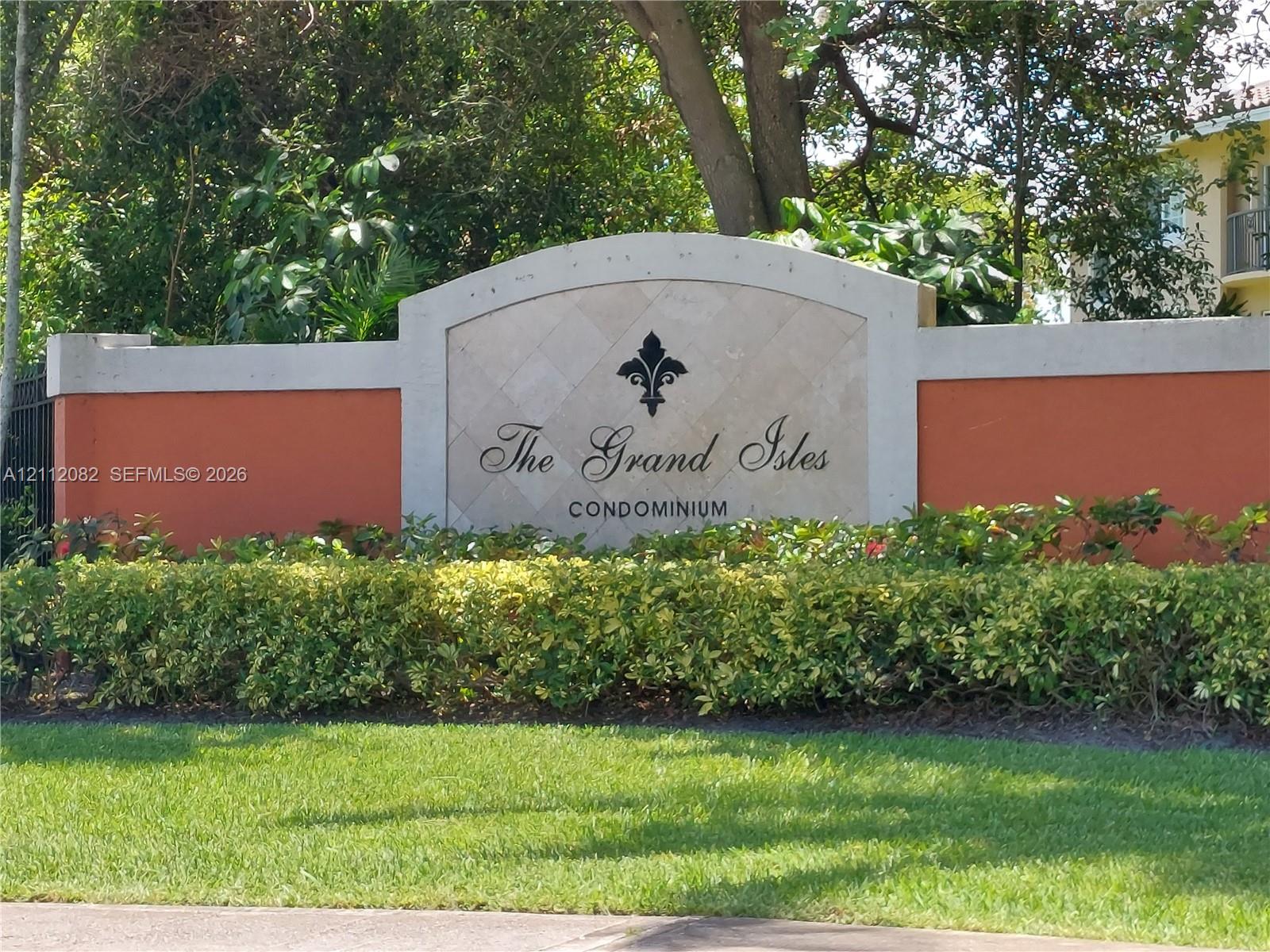 Community entrance monument featuring a stone-inlay center panel, arched concrete cap, and manicured landscaping Community entrance monument featuring a stone-inlay center panel, arched concrete cap, and manicured landscaping