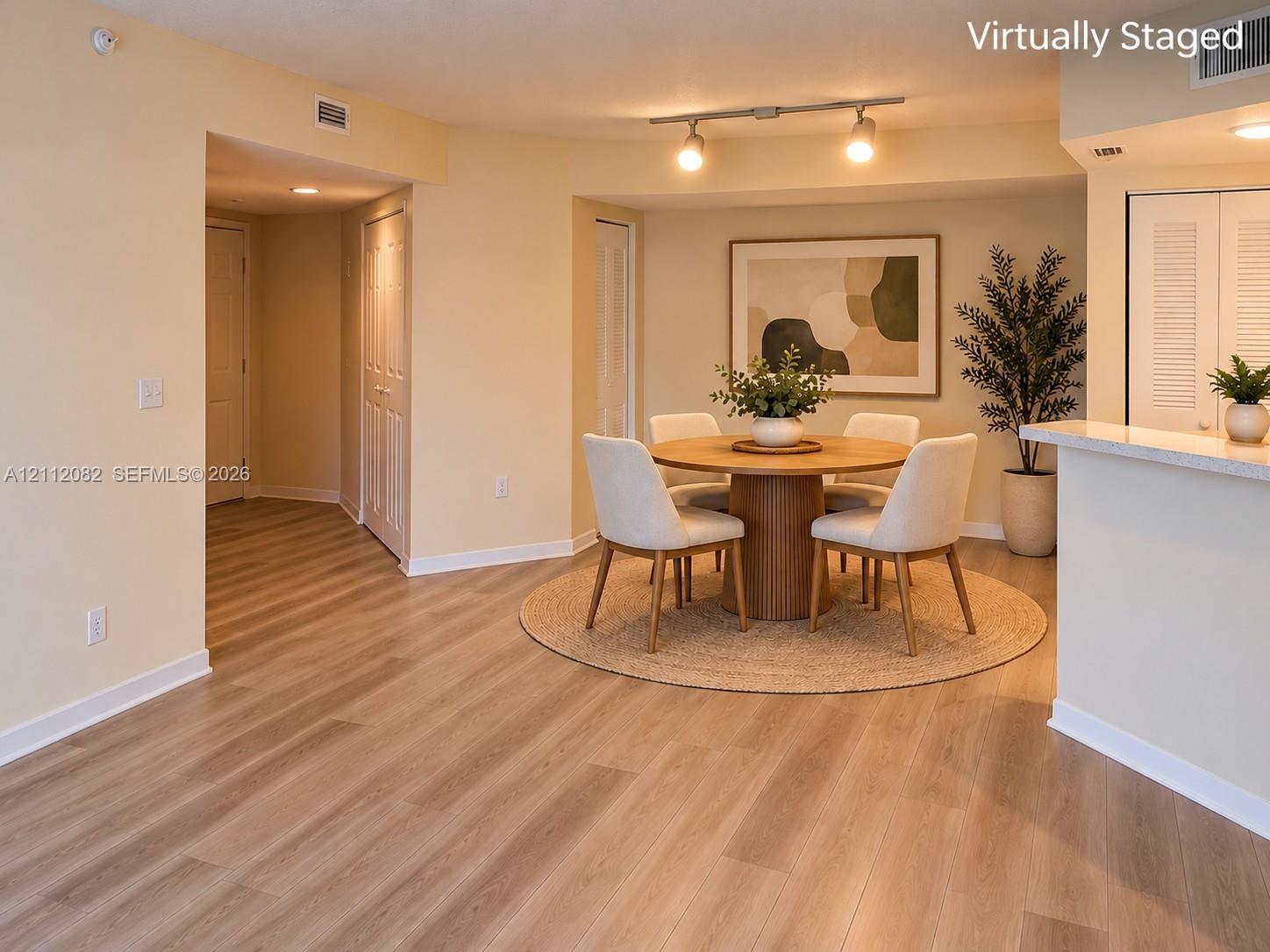 Interior space featuring wood-finish flooring, recessed lighting, track lighting, and a neutral color palette