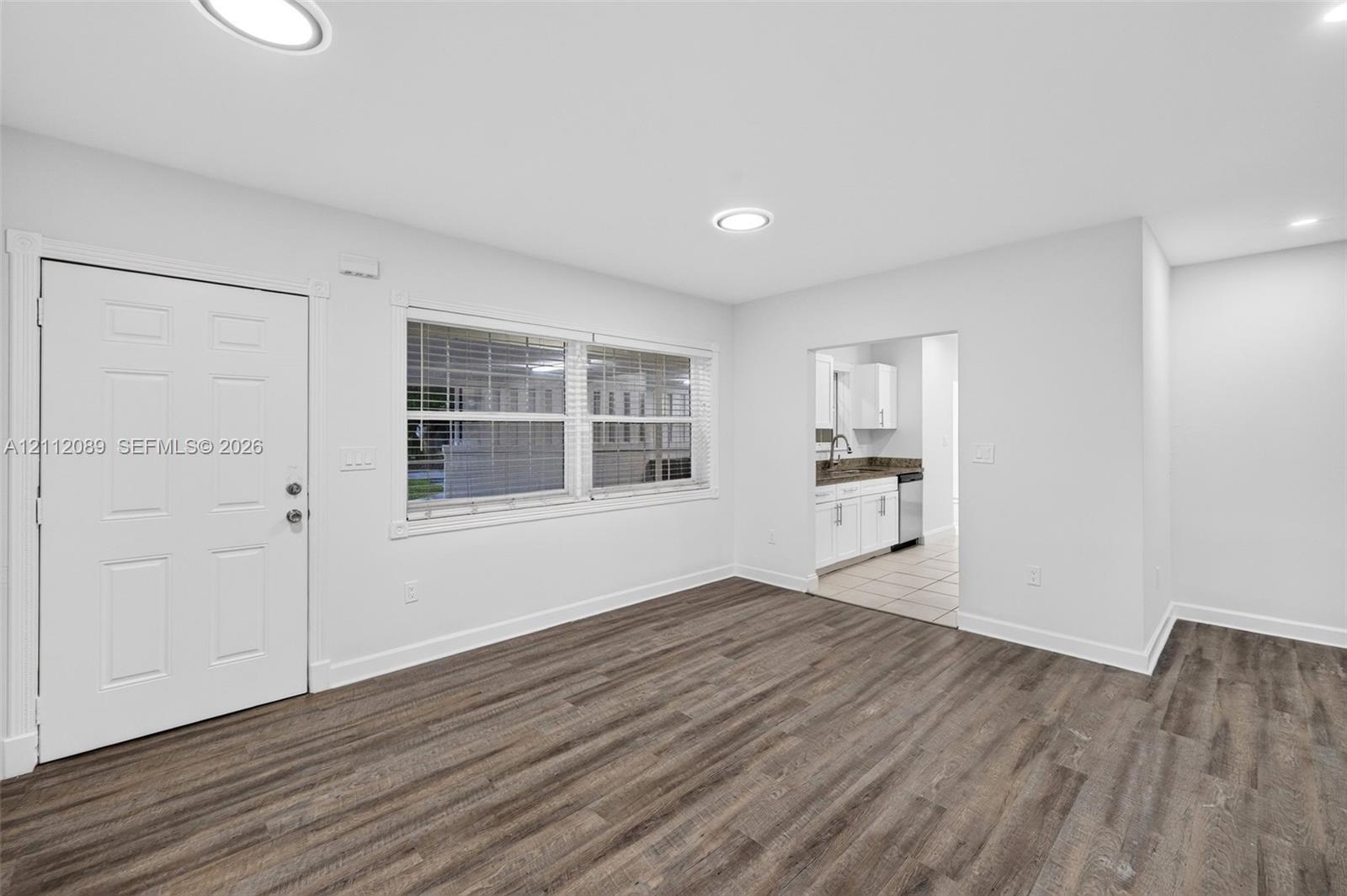 Interior space featuring wood-finish flooring, recessed lighting, and a six-panel entry door