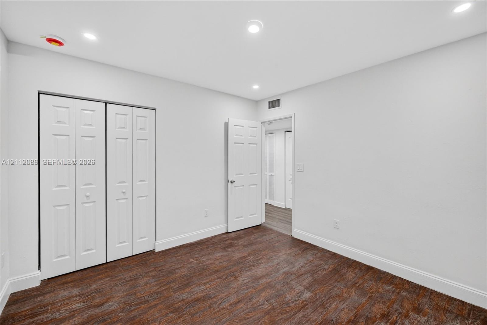 Interior room featuring wood-finish flooring, recessed lighting, and a bi-fold closet