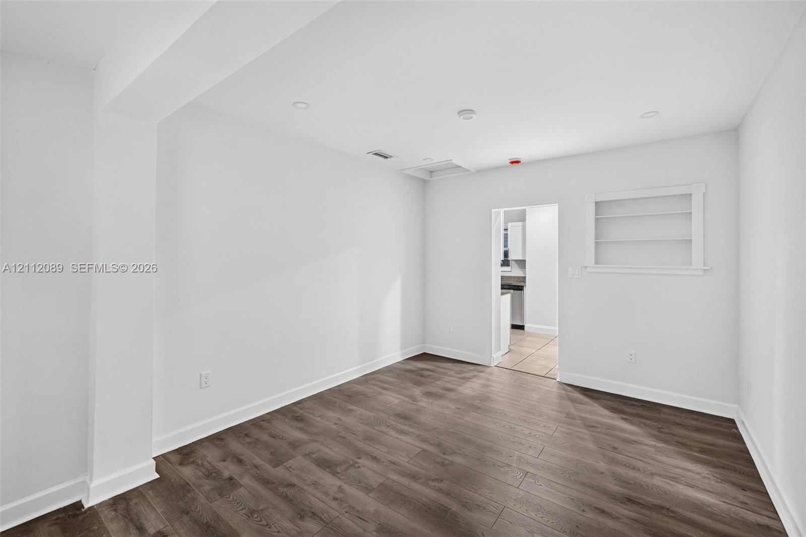 Interior room featuring wood-finish flooring, recessed lighting, and built-in wall shelving