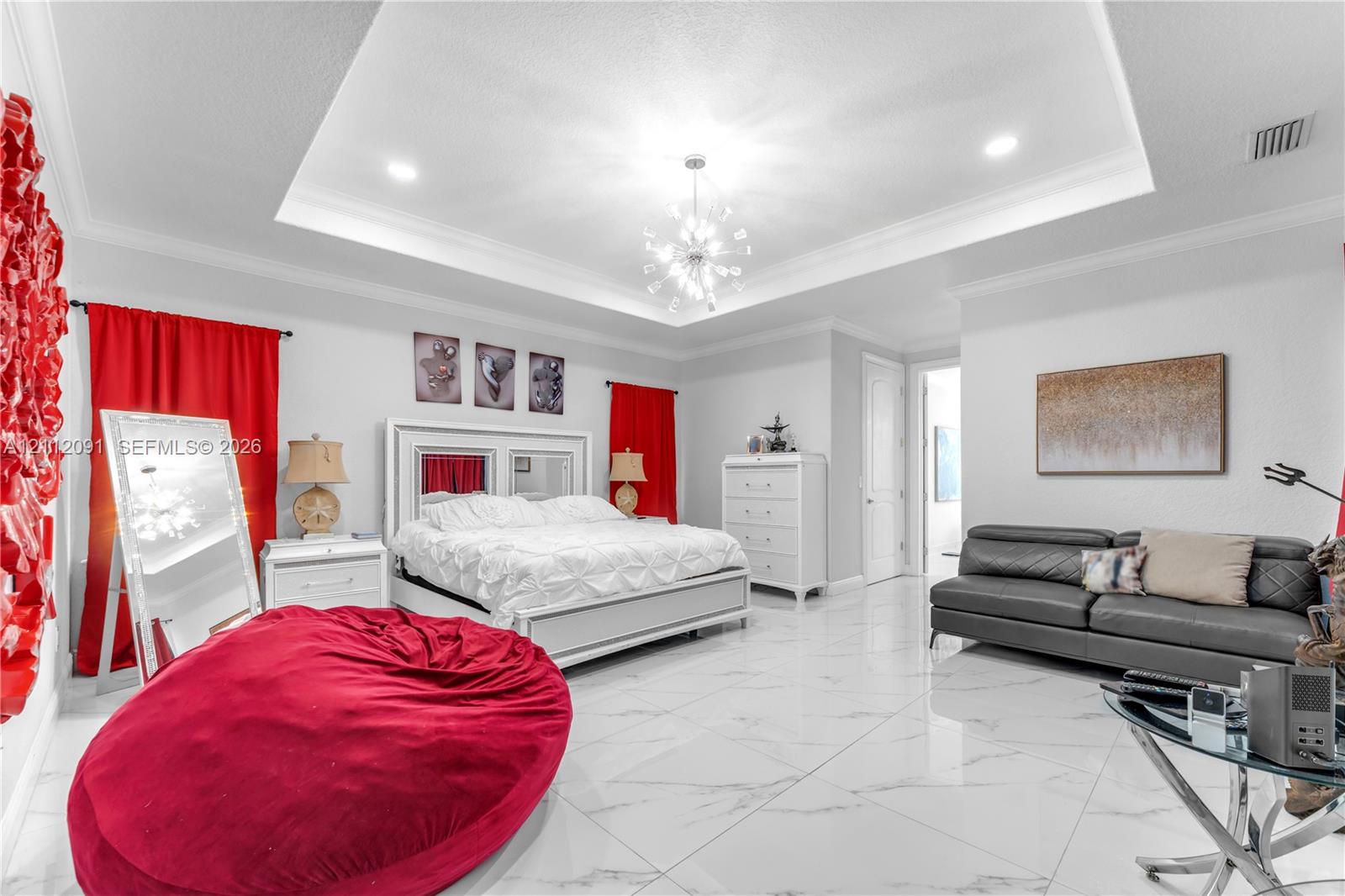Tray ceiling with recessed lighting, large-format tile flooring, and multi-arm chandelier