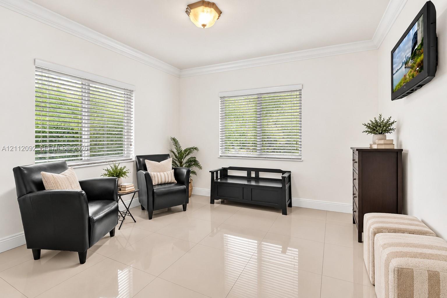 Neutral-toned tile flooring, dual windows with horizontal blinds, and crown molding