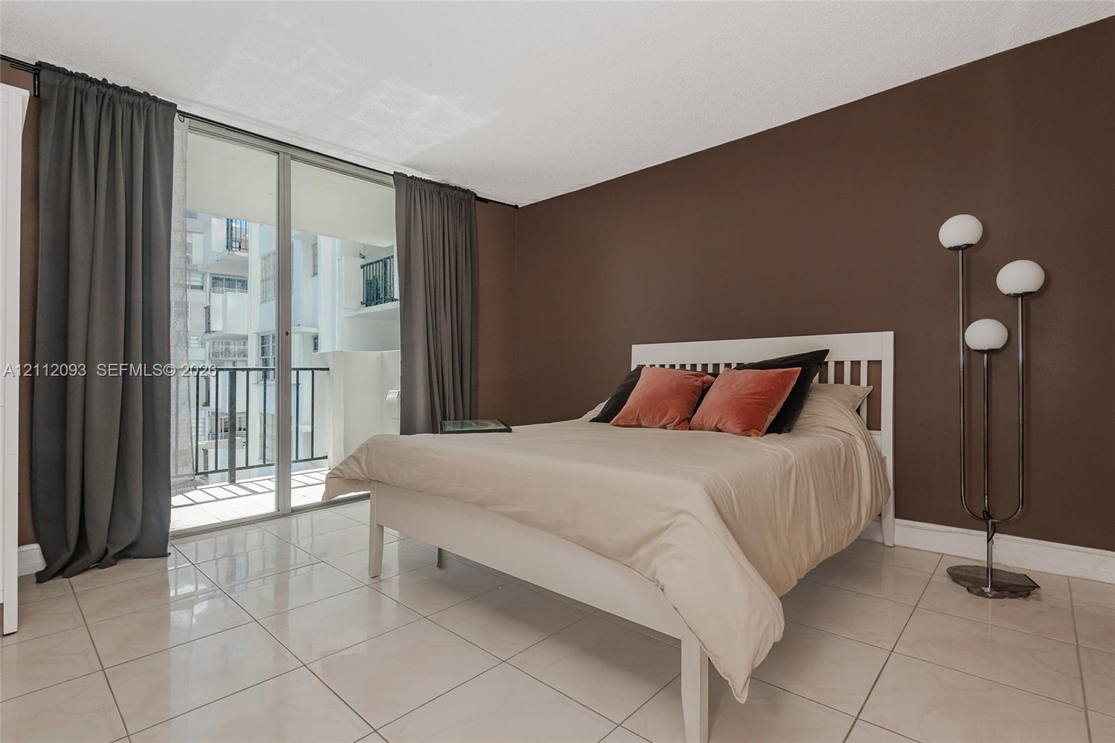 Polished tile flooring and sliding glass doors providing access to a private balcony