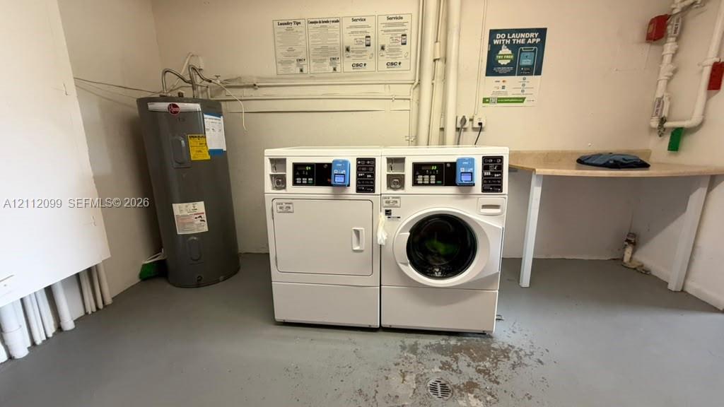 Laundry area featuring side-by-side coin-operated washer and dryer, tank-style water heater, and built-in laminate-surface folding counter