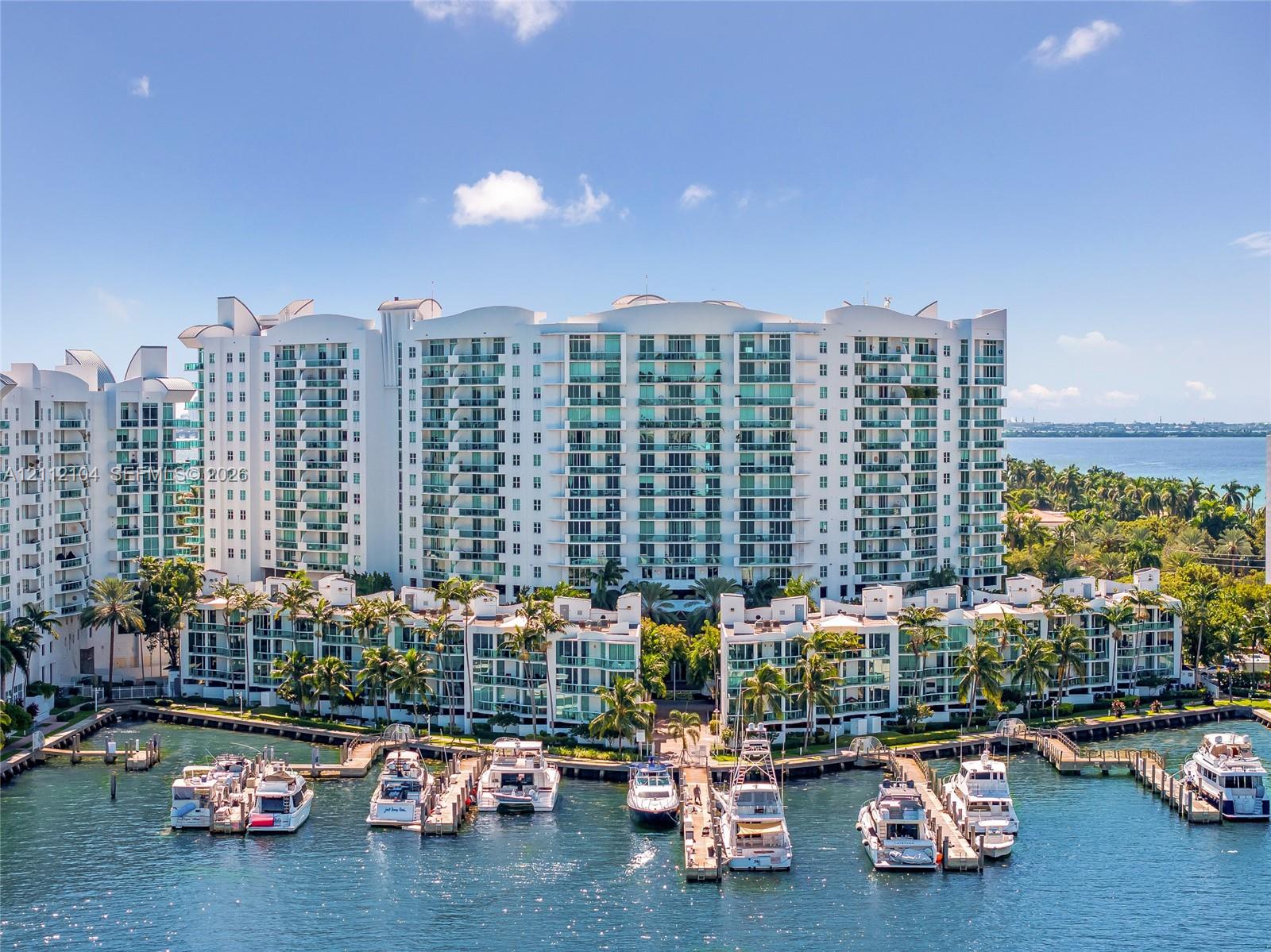 Multi-story residential complex featuring private boat slips, deep-water dockage, glass-railed balconies, and extensive perimeter landscaping Multi-story residential complex featuring private boat slips, deep-water dockage, glass-railed balconies, and extensive perimeter landscaping