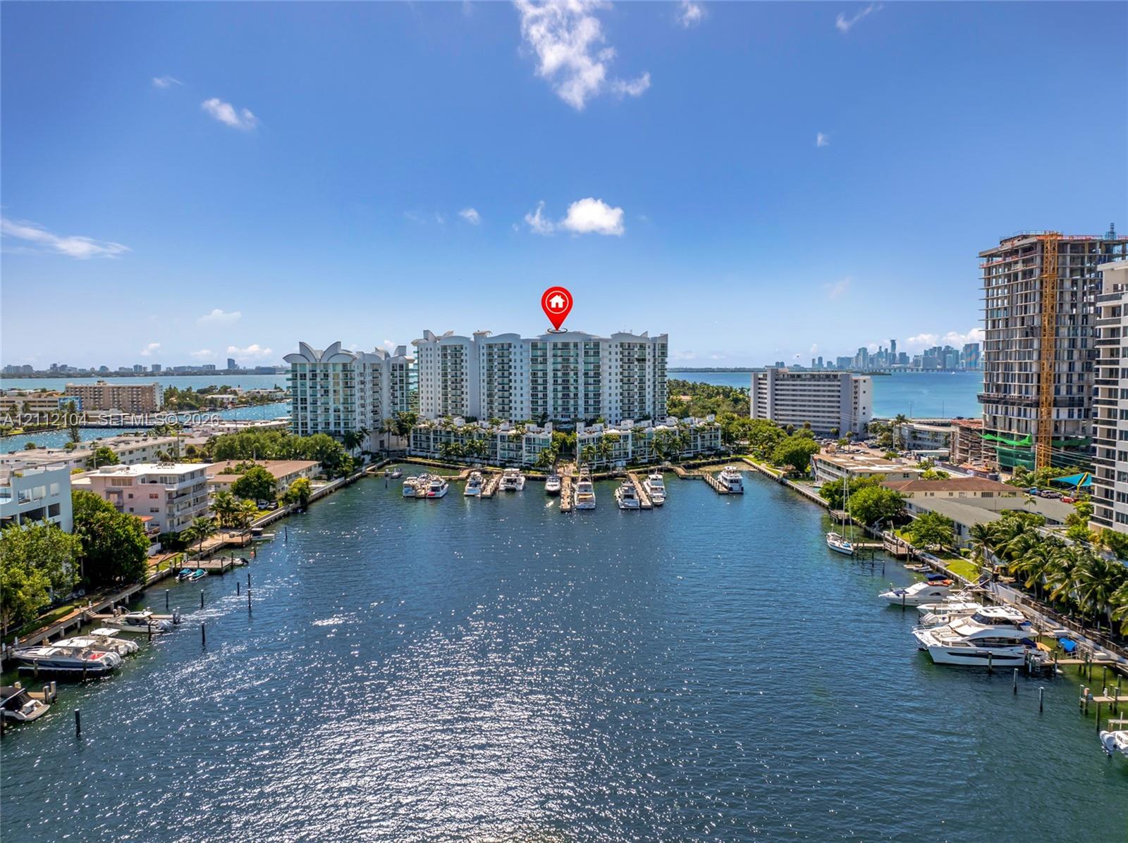 Waterfront high-rise building featuring a private deep-water marina, multiple boat slips, and coastal shoreline exposure