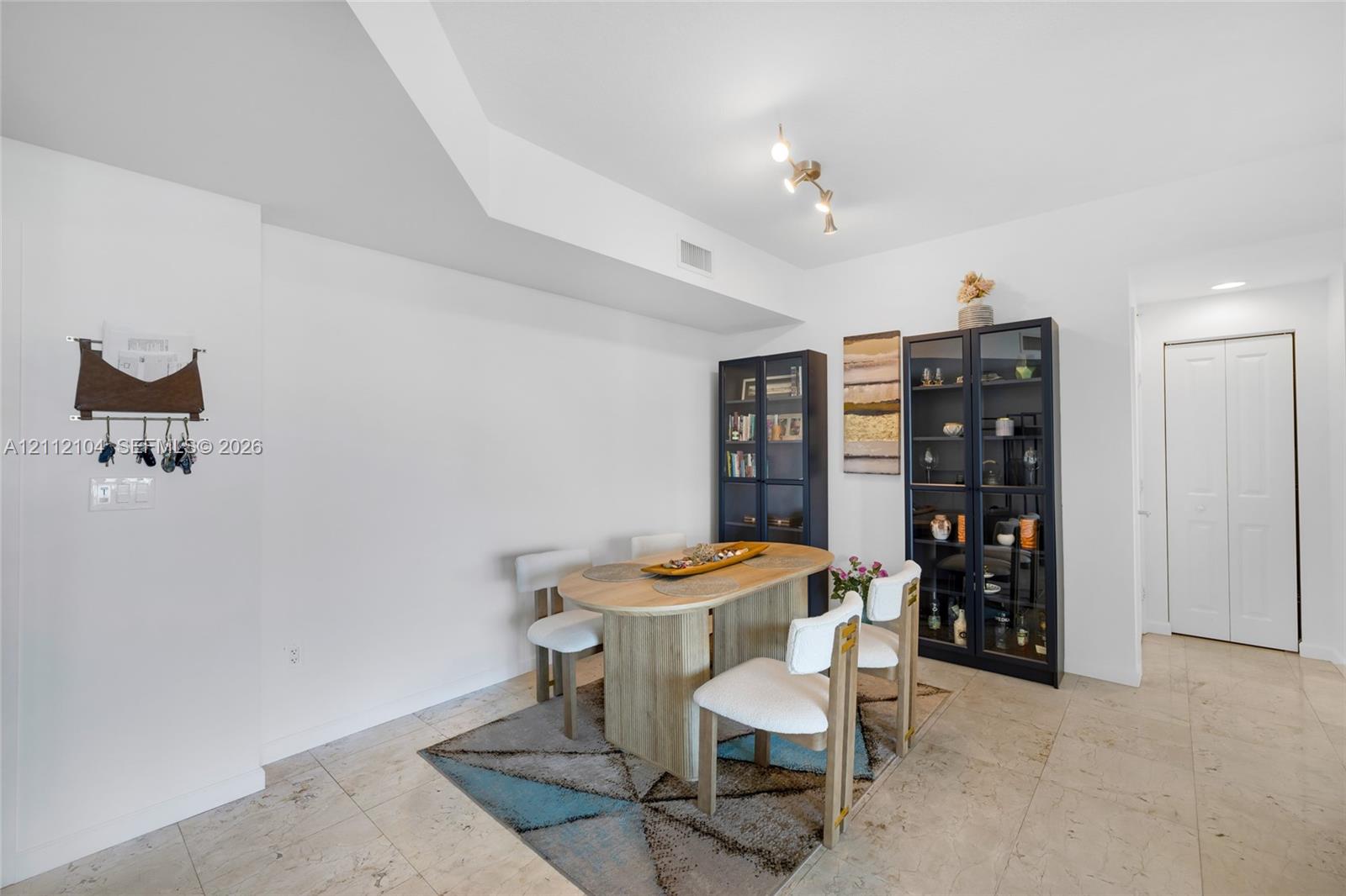 Neutral-toned tile flooring, recessed and track lighting, and double-door closet storage