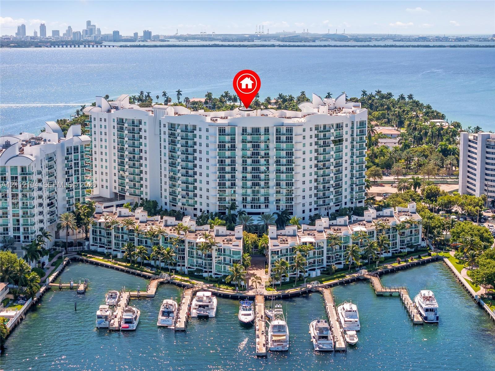 High-rise residential complex featuring private boat slips, balconies with glass railings, and water frontage