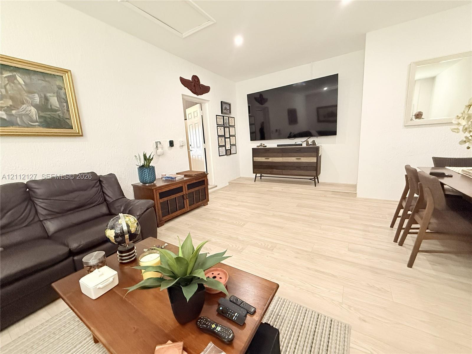 Living area featuring light-toned wood-finish flooring, recessed lighting, and a textured wall finish