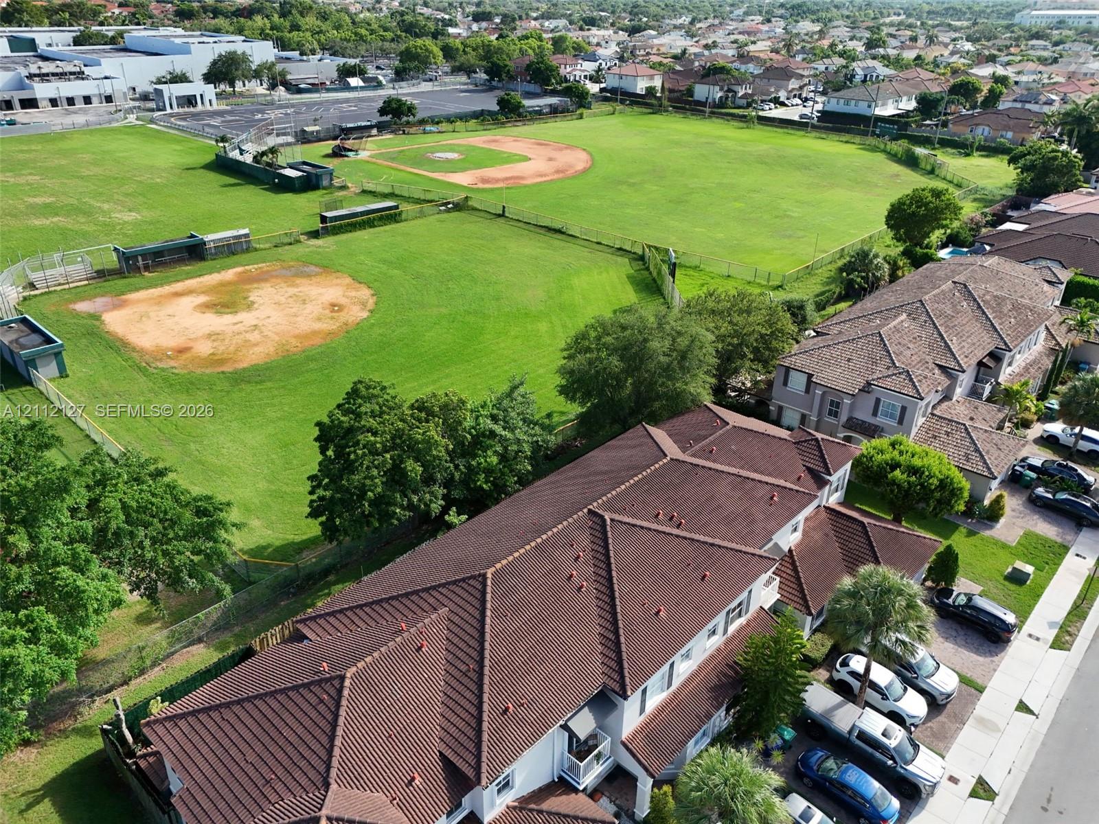 Aerial perspective of a multi-story residence featuring a multi-pitched tiled roof and concrete driveway