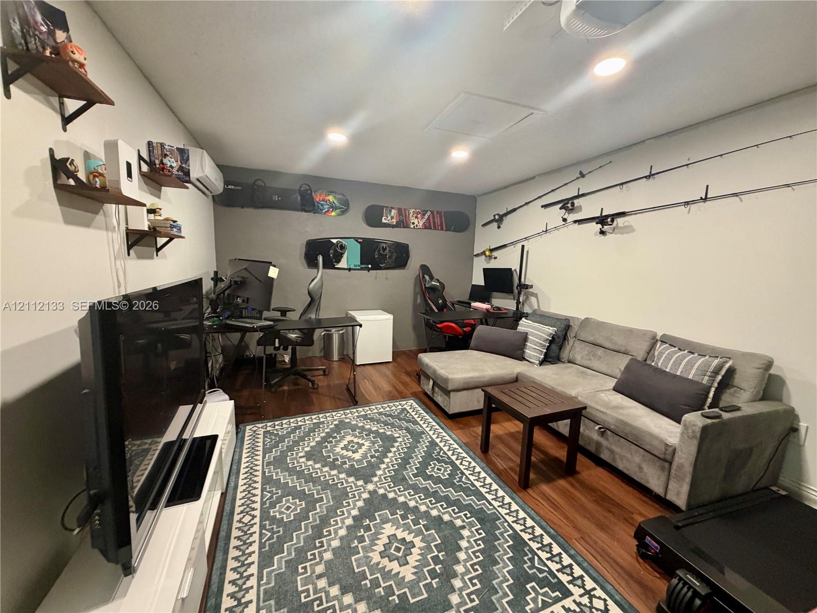 Interior room featuring wood-finish flooring, recessed lighting, and wall-mounted shelving units
