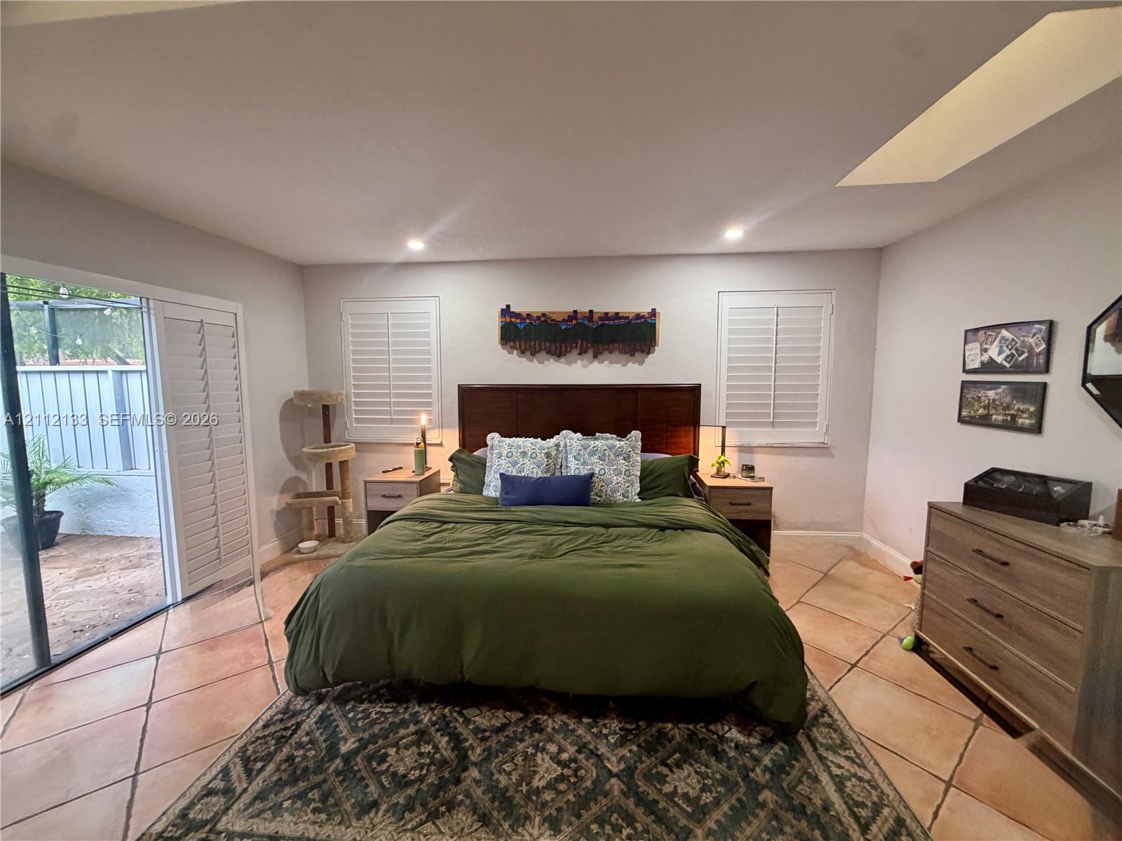 Tile flooring, plantation shutters, recessed ceiling lighting, and sliding glass doors