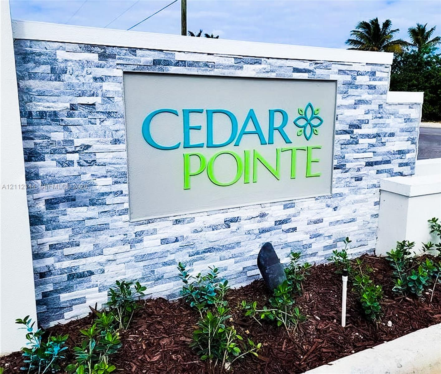 Community monument sign featuring stacked stone masonry, clean-lined concrete capped borders, and professional landscaping