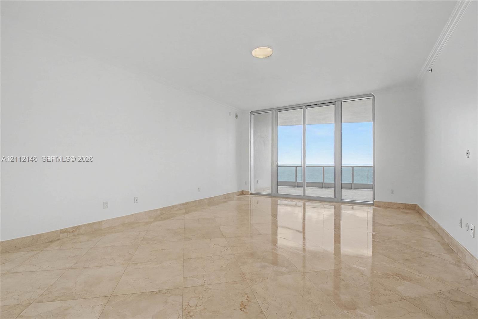 Polished stone flooring, floor-to-ceiling glass doors, and a private balcony