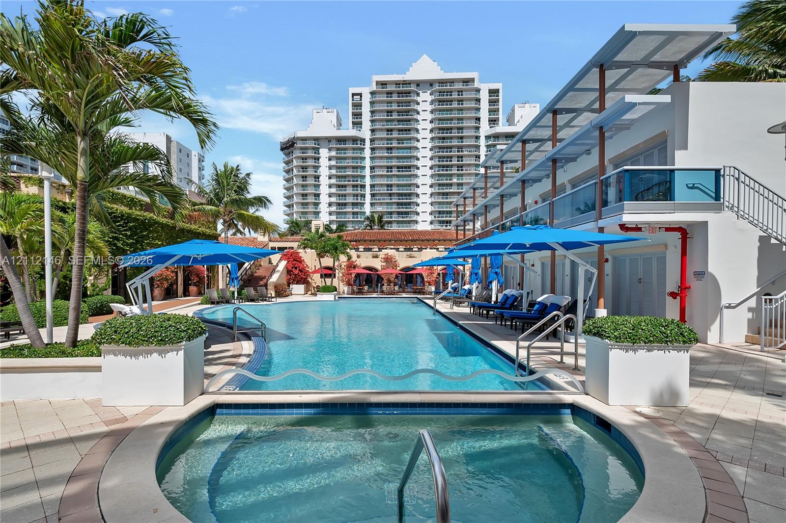 Outdoor swimming pool featuring a built-in spa, tile decking, integrated tiered levels, and overhead canopy shading