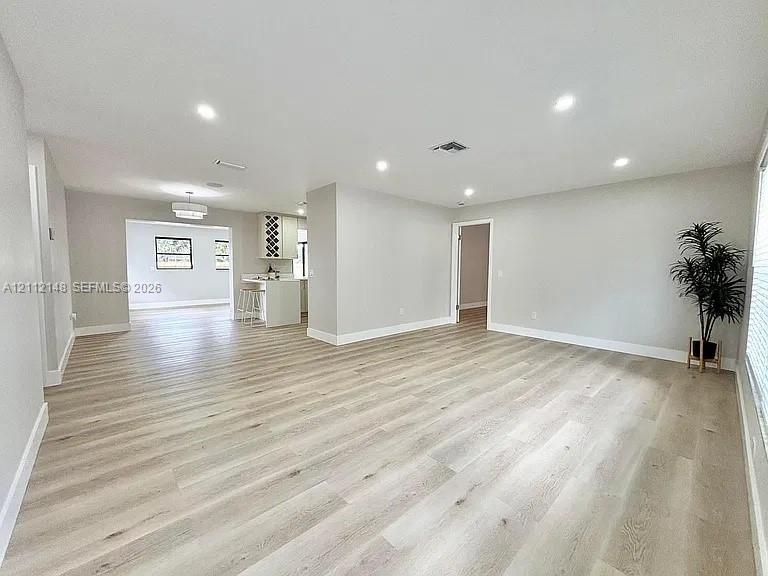 Open interior featuring wood-finish flooring, recessed lighting, and kitchen cabinetry with built-in wine storage