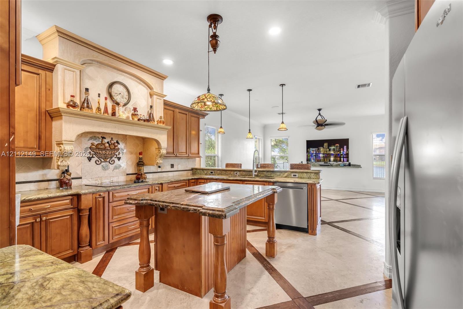 Kitchen featuring custom wood cabinetry, a central island with decorative corbels, stone countertops, a mosaic tile backsplash with a prominent range hood, and tile flooring with wood-tone inlay