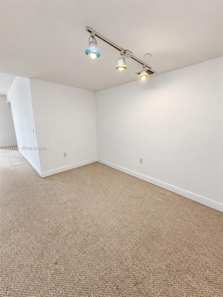 Neutral wall-to-wall carpeting and adjustable three-light track fixture
