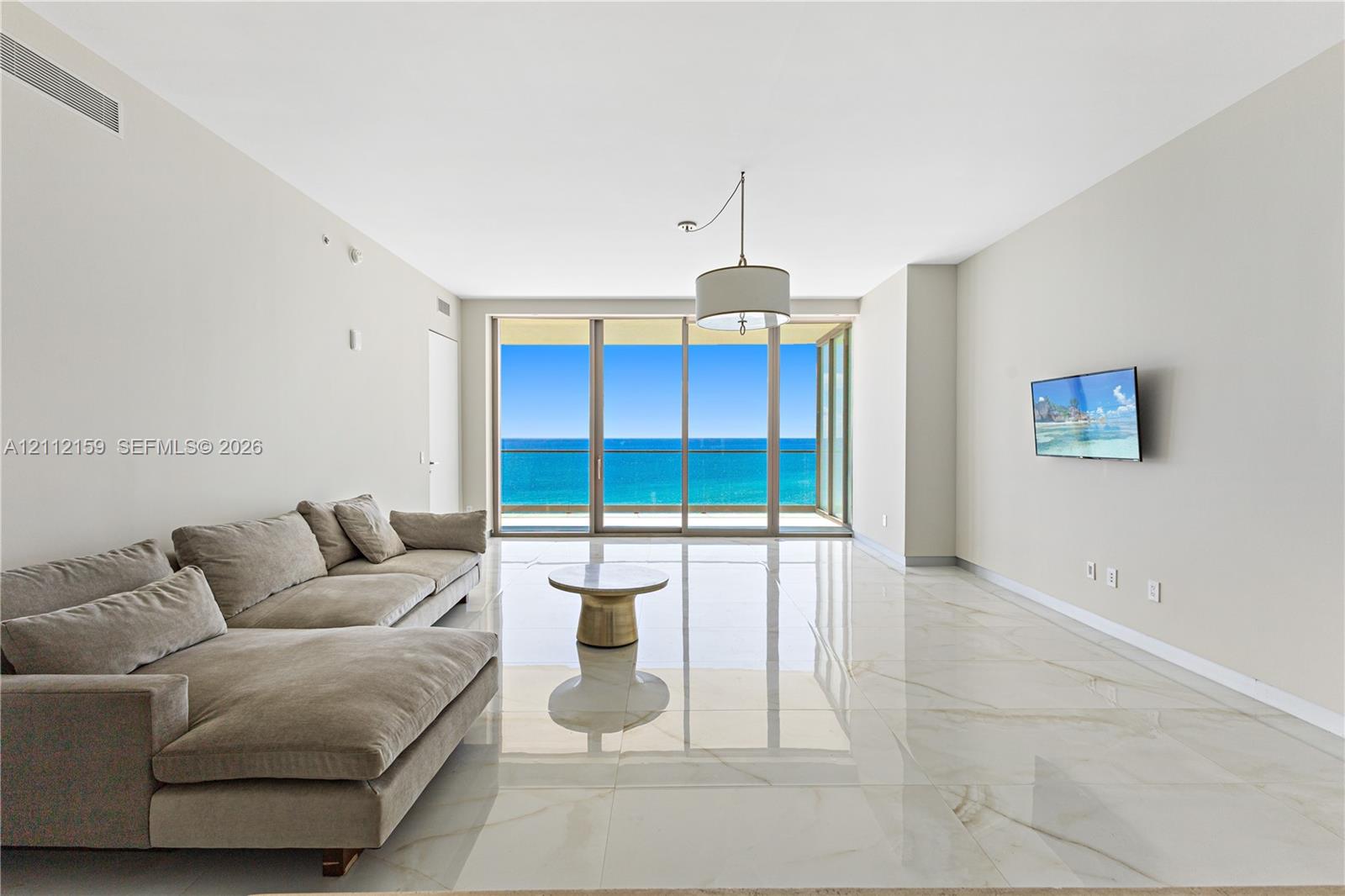Floor-to-ceiling sliding glass doors, polished stone-finish tile flooring, recessed lighting, and a pendant fixture Floor-to-ceiling sliding glass doors, polished stone-finish tile flooring, recessed lighting, and a pendant fixture