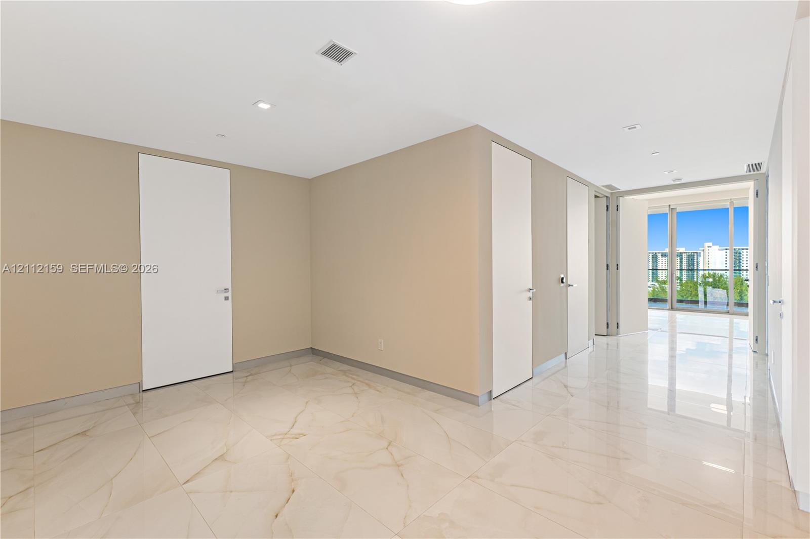Polished stone flooring with veining, recessed lighting, smooth-finish ceilings, and floor-to-ceiling glass panel doors