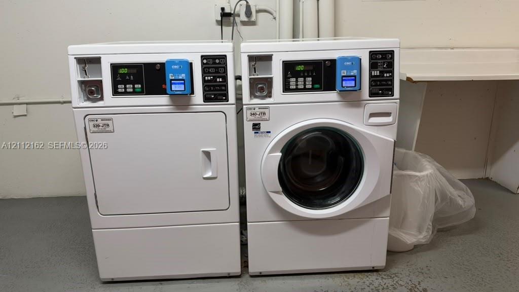 Commercial-grade laundry appliances featuring digital control panels, coin-operated mechanisms, and white finish