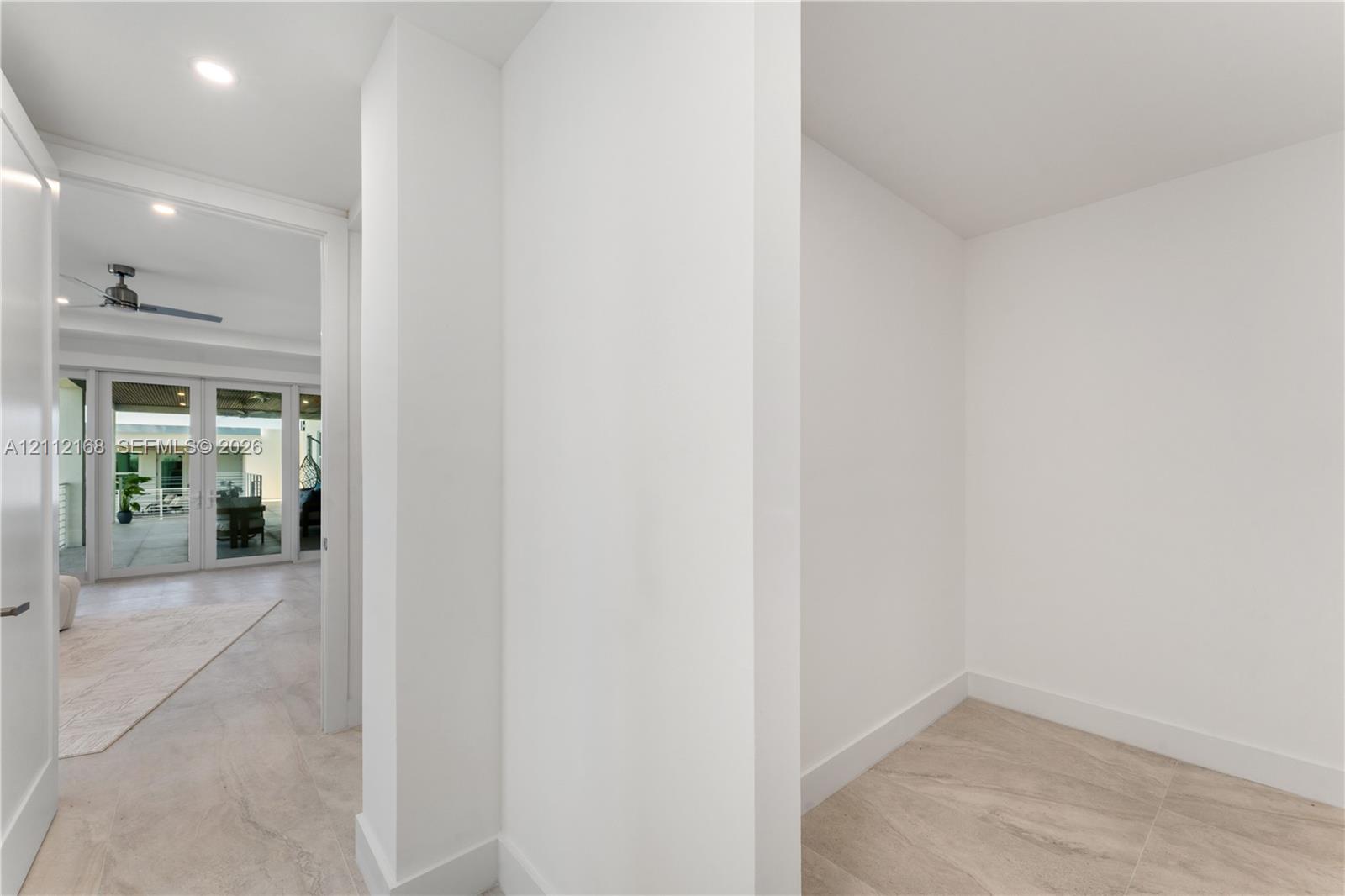 Neutral interior featuring smooth white wall finishes, recessed lighting, and stone-finish tile flooring