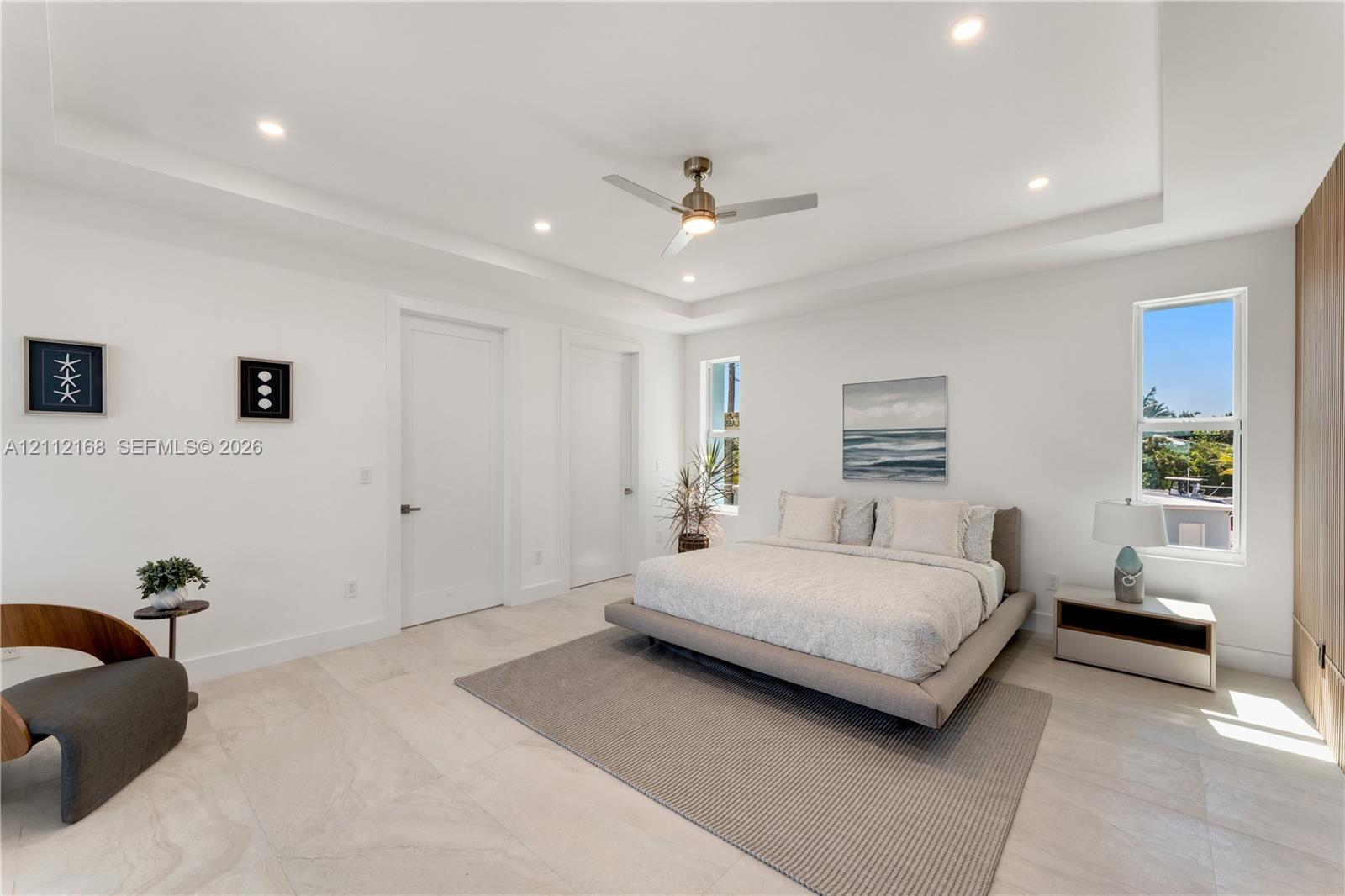Tray ceiling featuring recessed lighting, a central ceiling fan, large-format tile flooring, and floor-to-ceiling wood-finish cabinetry
