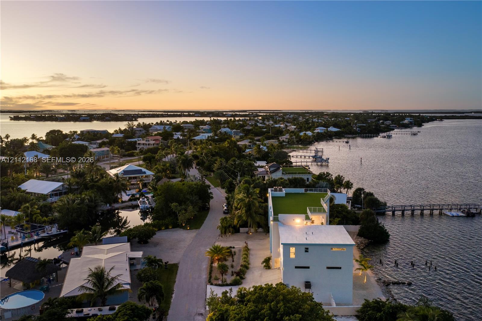 Waterfront property featuring a rooftop deck, private dock, multi-level exterior, and coastal location