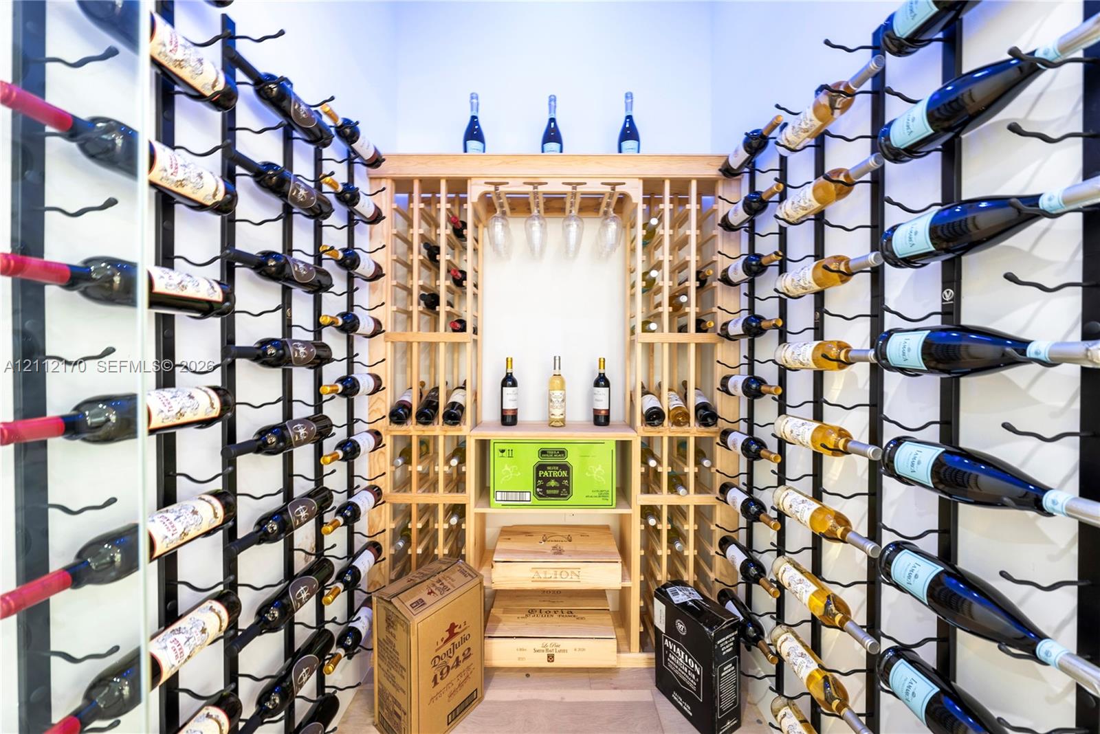 Custom wine cellar featuring extensive grid-style metal bottle racking, integrated wooden shelving, and built-in stemware storage