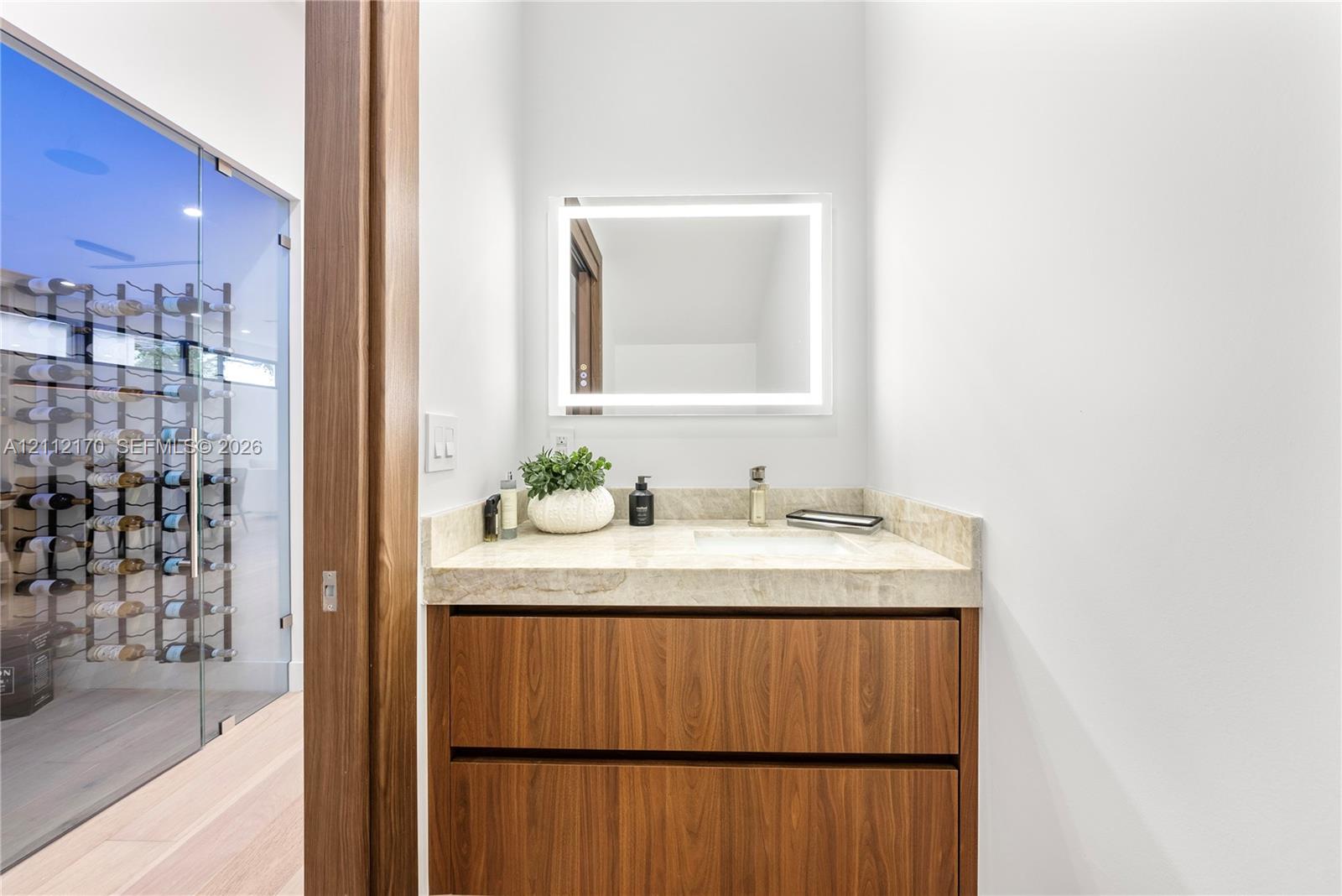 Vanity featuring a natural stone countertop, undermount sink, and wood-finish cabinetry