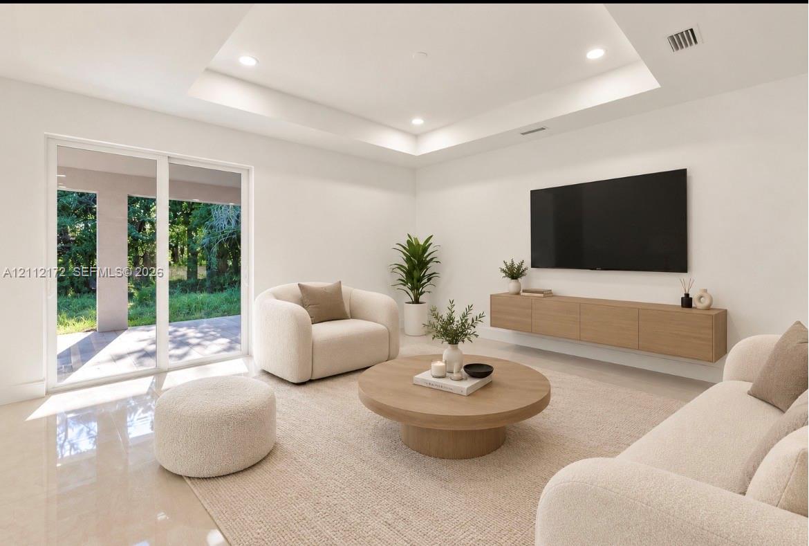 Tray ceiling with recessed lighting, large sliding glass doors, and wall-mounted cabinetry Tray ceiling with recessed lighting, large sliding glass doors, and wall-mounted cabinetry